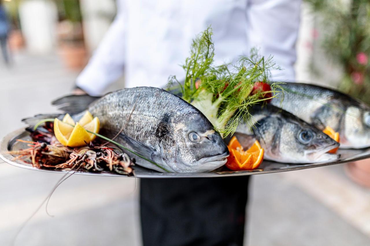 Lighthouse Golf & Spa Hotel Balcsik Kültér fotó A waiter holding a platter of fish